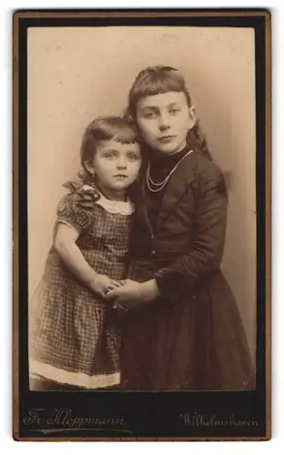 Fotografie Fr. Kloppmann, Wilhelmshaven, Oldenburgerstr. 16, Zwei sich an den Händen haltende junge Mädchen in Kleidern