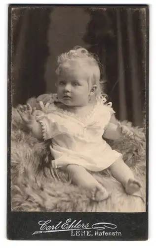 Fotografie Carl Ehlers, Lehe, Hafenstr., Kleines Mädchen mit blondem Haar in weissem Spitzenkleid und barfuss