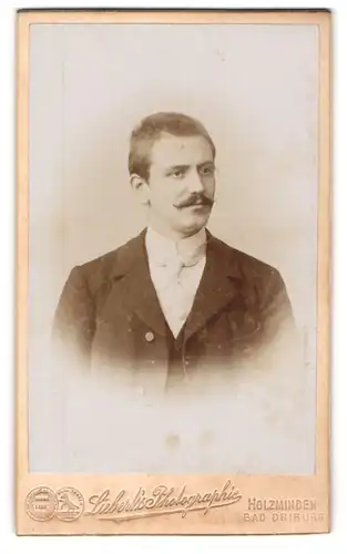 Fotografie Liebert`s Photographie, Holzminden, Karl-Str. 19, Herr mit Bürstenhaarschnitt in schwarzem Anzug