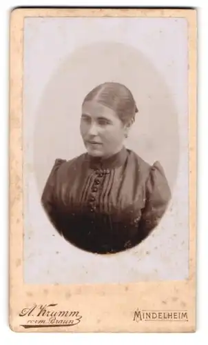 Fotografie A. Krumm, vorm. Braun, Mindelheim, Junge Dame mit strenger Frisur im schwarzen Kleid mit hohem Kragen