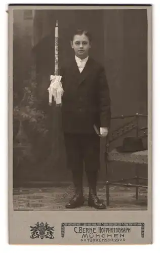 Fotografie C. Berne, München, Türkenstr. 20, junger Knabe im dunklen Anzug mit Kerze zur Kommunion