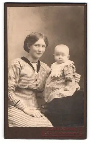 Fotografie Gustav Schmidt, Leck, Bahnhofstr., junge Mutter im gestreiften Kleid mit Kleinkind im Atelier, Mutterglück