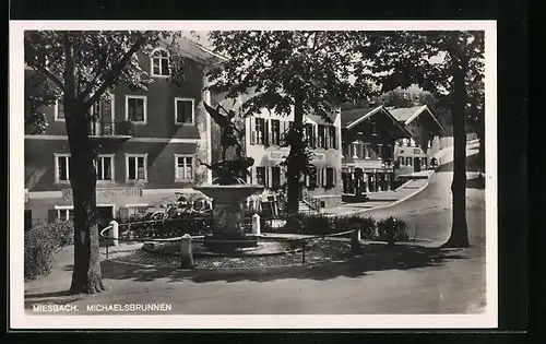 AK Miesbach, Strassenpartie mit Geschäften und Michaelsbrunnen
