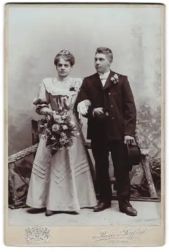 Fotografie Bosio & Seyfried, Judenburg, Brautleute im Hochzeitskleid und Anzug mit Brautstrauss im Atelier