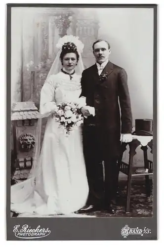 Fotografie E. Riechers, Brand i. Sa., Eheleute im weissen Hochzeitskleid mit Schleier und im Anzug mit Zylinder