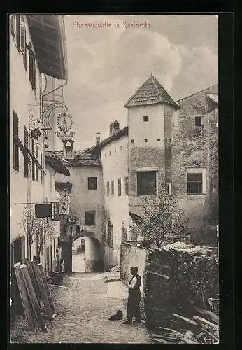 AK Kastelruth, Strassenpartie mit Holzstapel und Einwohner
