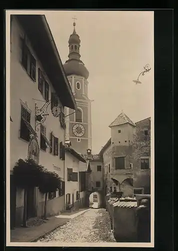 AK Kastelruth, Strassenbild mit Blick auf Kirche und Tordurchgang