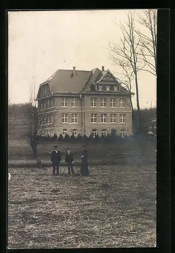 Foto-AK Bittenfeld, Zwei Herren und eine Dame vor dem Schulhaus im Jahr 1916