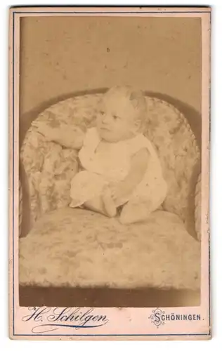 Fotografie H. Schilgen, Schöningen, Junges Kleinkind auf gepolstertem Stuhl