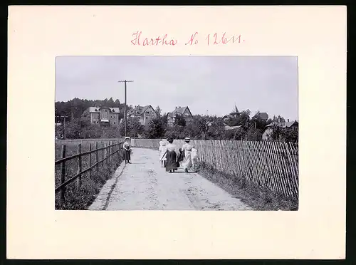 Fotografie Brück & Sohn Meissen, Ansicht Bad Hartha, Damen in Kleidern spazieren mit Blick zum Ort