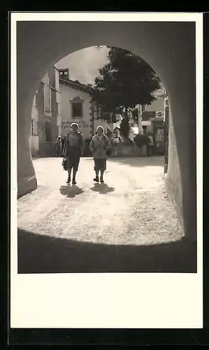 Foto-AK Kastelruth, Strassenpartie am Tor mit zwei Frauen