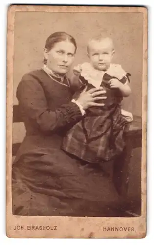 Fotografie Joh. Brasholz, Hannover, Mutter mit Kleinkind im karierten Kleidchen auf dem Arm, Mutterglück