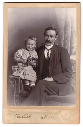 Fotografie Geo Frank, Gateshead, Vater sitzt neben seinem Kind, Mutterglück