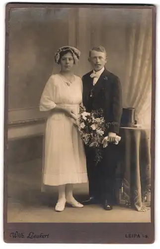 Fotografie Wilh. Leukert, Leipa i. B., Hochzeitspaar mit Blumenstrauss und Zylinder