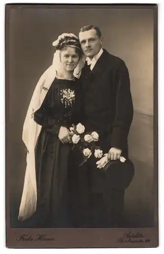 Fotografie Fritz Haase, Görlitz, Brautpaar im schwarzen Kleid mit Blumenstickerei und Zylinder