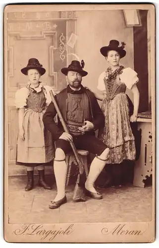 Fotografie F. Largajoli, Meran, Schütze Oscar Braun mit Büchse und Töchtern Adrienne, Alice Olga in Trachtenkleidern