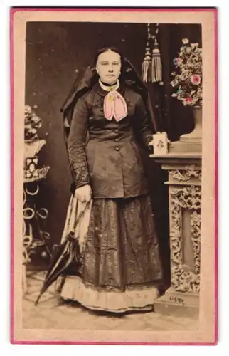Fotografie unbekannter Fotograf und Ort, Frau aus Kremsmünster im Trachtenkleid mit Kopftuch und Schirm