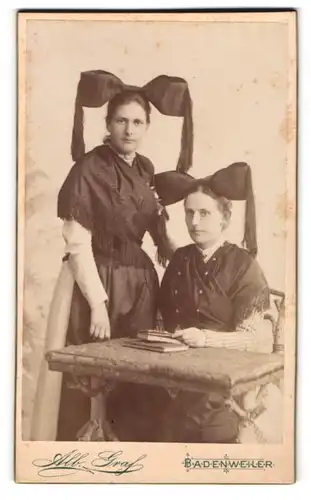 Fotografie Alb. Graf, Badenweiler, zwei junge Frauen in Trachtenkleidern mit Schleife auf dem Kopf