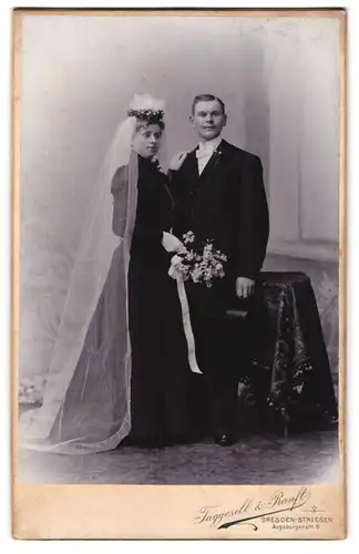 Fotografie Taggesell & Ranft, Dresden-Striesen, Hochzeitspaar im schwarzen Kleid mit Blumenstrauss und Zylinder