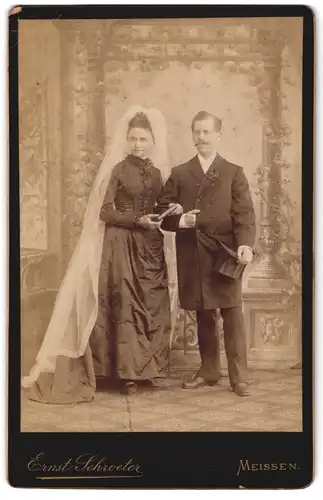 Fotografie Ernst Schroeter, Meissen, Braut im schwarzen Kleid mit Schleier neben ihrem Mann im Anzug