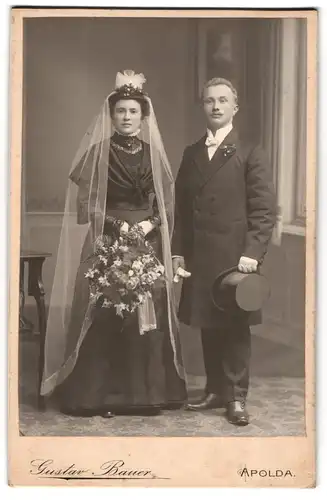 Fotografie Gustav Bauer, Apolda, Junges Brautpaar im schwarzen Kleid mit Blumenstrauss und Zylinder