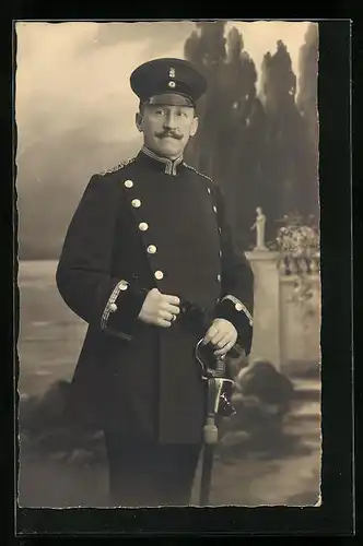 Foto-AK Soldat in Uniform mit Schirmmütze und Degen, Uniformfoto