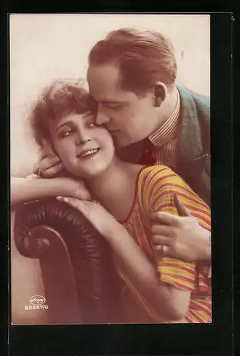 Foto-AK Amag: Junge Frau auf einer Couch wird von einem Mann geküsst