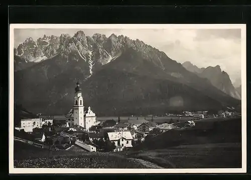 AK Dobbiaco, Ortstotale mit der Kirche gegen die Dolomiten