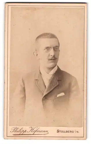 Fotografie Philipp Hofmann, Stollberg i. S., Junger Mann mit Zwicker und Moustache im Anzug mit Stecktuch