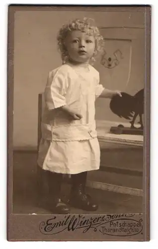 Fotografie Emil Winzer & Sonne, Potschappel, Tharandterstrasse 10, Niedliches Kleinkind mit Löckchen und weissem Kleid