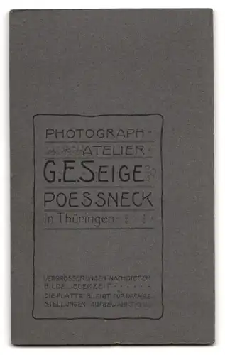 Fotografie G. E. Seige, Pössneck i. Th., Süsses Kleinkind in weissem Kleidchen auf einem Pelz