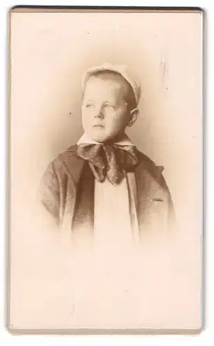 Fotografie unbekannter Fotograf und Ort, Bub in eleganter Kleidung mit Kopfbedeckung