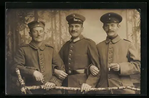 Foto-AK Drei Soldaten in Uniform, einer rauchend mit Brille