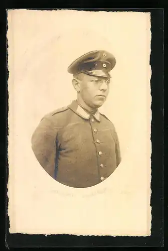 Präge-AK Soldat mit Schirmmütze und Brille, Uniformfoto