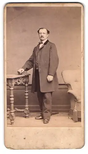 Fotografie Langer & Pommerrenig, Prag, Portrait Herr im Anzug mit Fliege und Moustache