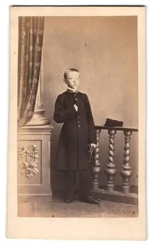 Fotografie unbekannter Fotograf und Ort, Portrait junger Knabe im dunklen anzug mit Mantel in Napoleon Geste