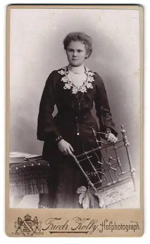 Fotografie Friedr. Kolby, Zwickau, Plauensche Str., eine junge Frau hält einen Stuhl