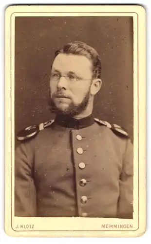 Fotografie J. Klotz, Memmingen, Portrait Soldat in Uniform mit Epauletten und Brille, 1877