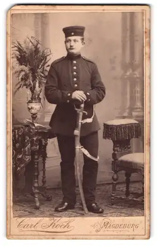 Fotografie Carl Koch, Magdeburg, Portrait Soldat in Uniform mit Säbel und Krätzchen