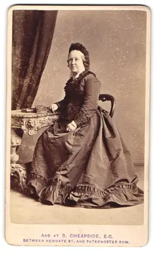 Fotografie J. L. Jurner, Islington, ältere Dame im dunklen Biedermeierkleid mit Haube sitzend im Atelier