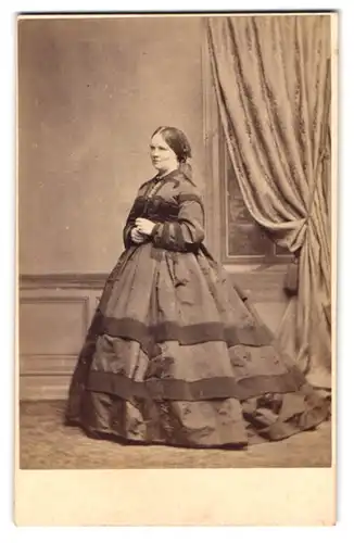 Fotografie White, Glasgow, Portrait Dame im dunklen Reifrockkleid mit Kopftuch steht posierend im Atelier