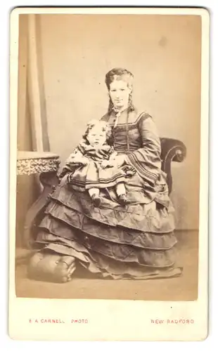 Fotografie E. A. Carnell, New Radford, Mutter im gerafften Biedermeierkleid mit Töchterchen auf dem Schoss