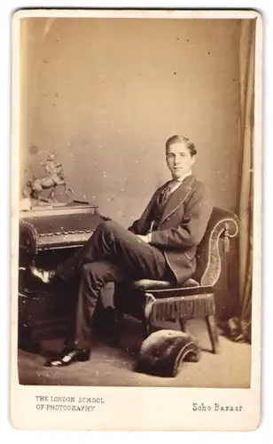 Fotografie London School of Photography, London, junger Mann im feinen Anzug mit Lackschuhen sitzend im Atelier