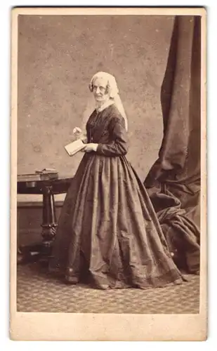 Fotografie Hills & Saunders, London-Harrow, ältere Dame im dunklen Kleid mit Haube und Korkenzieherlocken