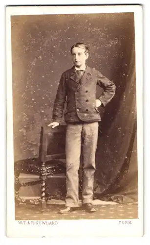 Fotografie W. T. & R. Gowland, York, junger englischer Knabe im Anzug posiert lässig stehend im Atelier