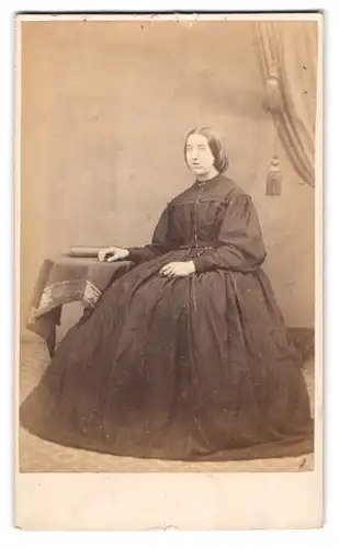Fotografie Samuel Fry & Co., London, Dame im schwarzen Reifrockkleid sitzend im Atelier