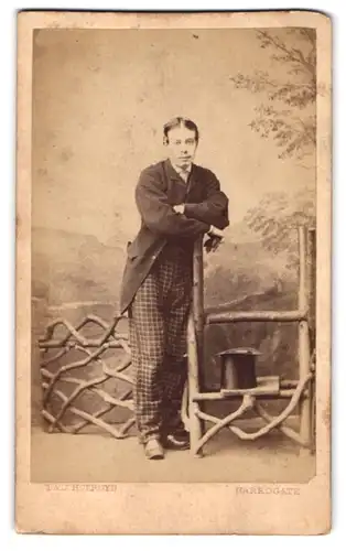 Fotografie T. & J. Holroyd, Harrogate, junger Engländer im karierten Anzug mit Zylinder posiert im Atelier