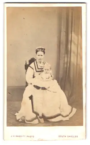 Fotografie J. H. Haggitt, South Shields, Mutter im hellen Kleid mit Kind auf dem Schoss