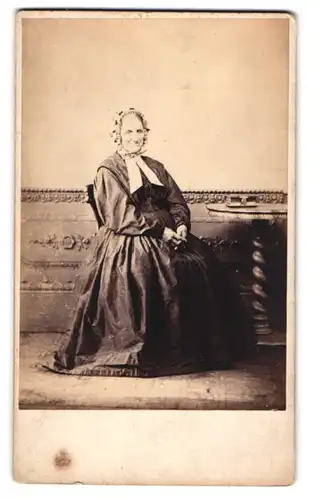 Fotografie Wm. Barraclough, Otley, ältere Dame im Biedermeierkleid mit Haube sitzend im Atelier