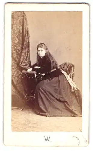 Fotografie Walery, Marseille, junge Frau im dunklen Kleid mit Samtjacke und offenen Haaren